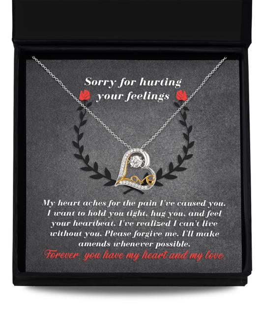 An open gift box reveals the Sorry-Make Amends - Love Dancing Necklace, a genuine sterling silver heart-shaped pendant inscribed with "Love" and accompanied by a heartfelt message apologizing for hurt feelings, expressing the sender's regret and sincere desire to make amends.