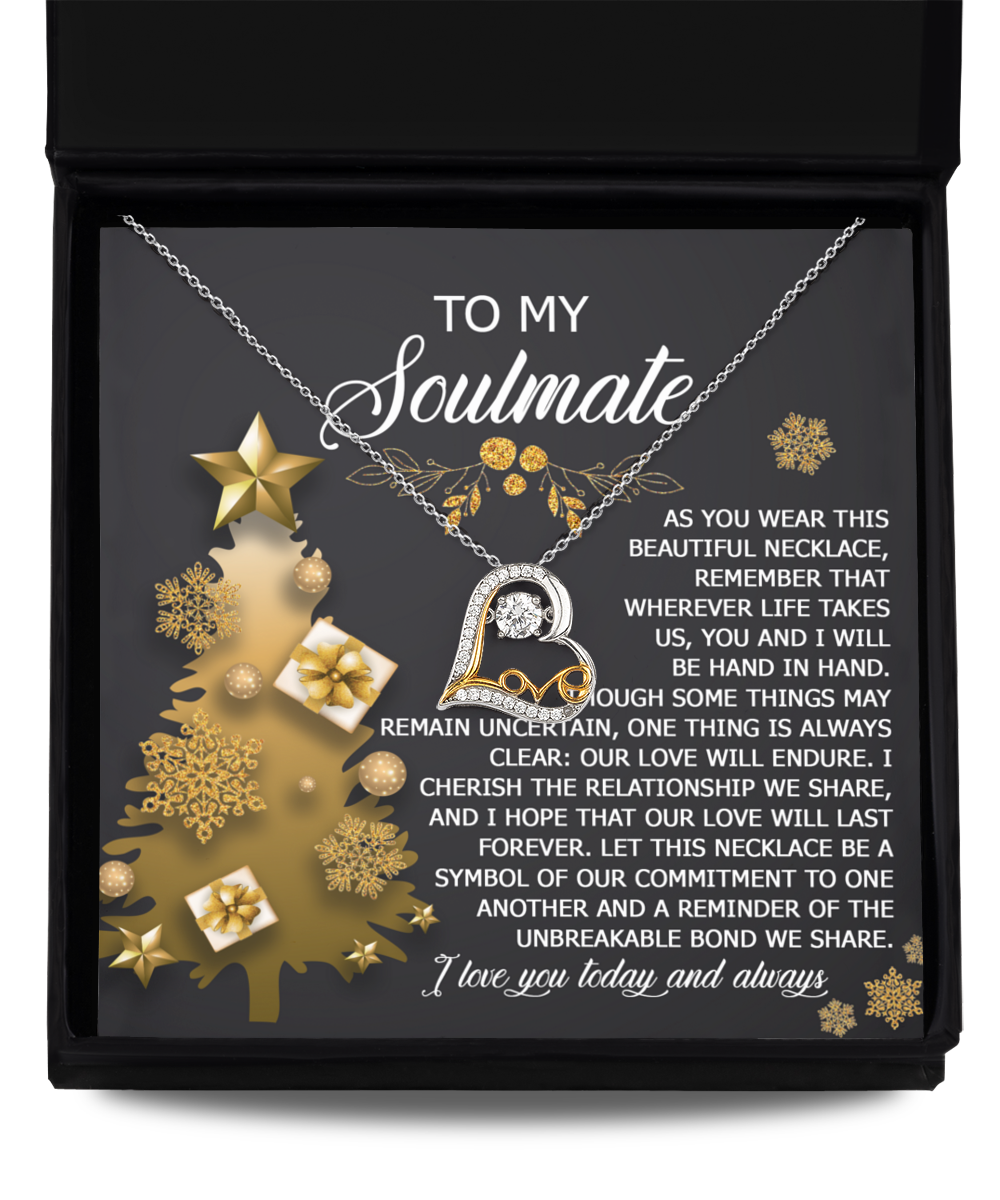 A Soulmate-Be A Symbol - Love Dancing Necklace, featuring a heart pendant, is showcased in a box. The message inside says, "To my soulmate... I cherish the relationship we share... I love you today and always." Sterling silver accents beautifully enhance the gold decorations on the box.