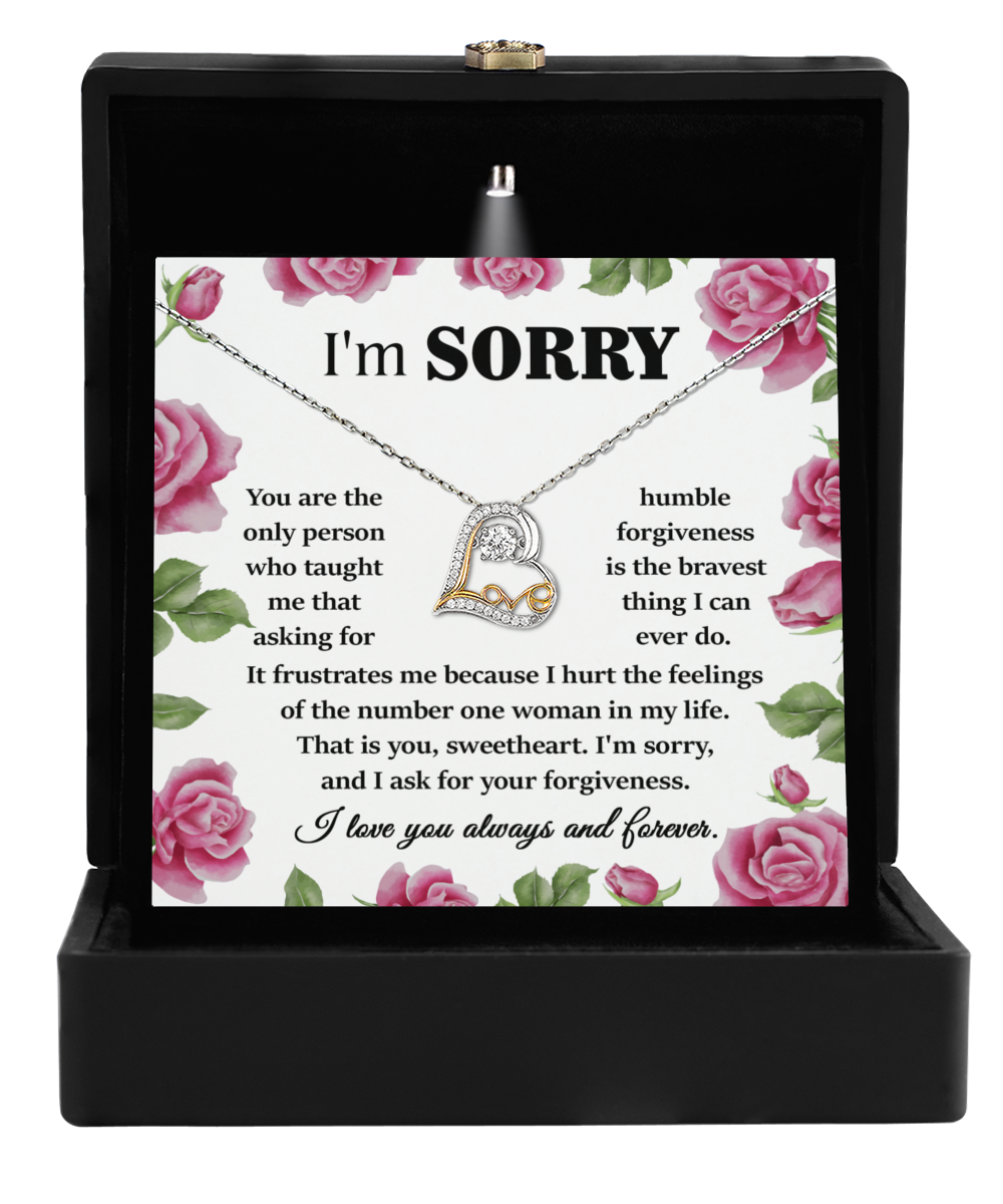 A box containing the "Sorry-Your Forgiveness - Love Dancing Necklace" with a 14k gold heart-shaped pendant adorned with a small crystal and an accompanying note that apologizes for hurting feelings, asks for forgiveness, and expresses love and gratitude.