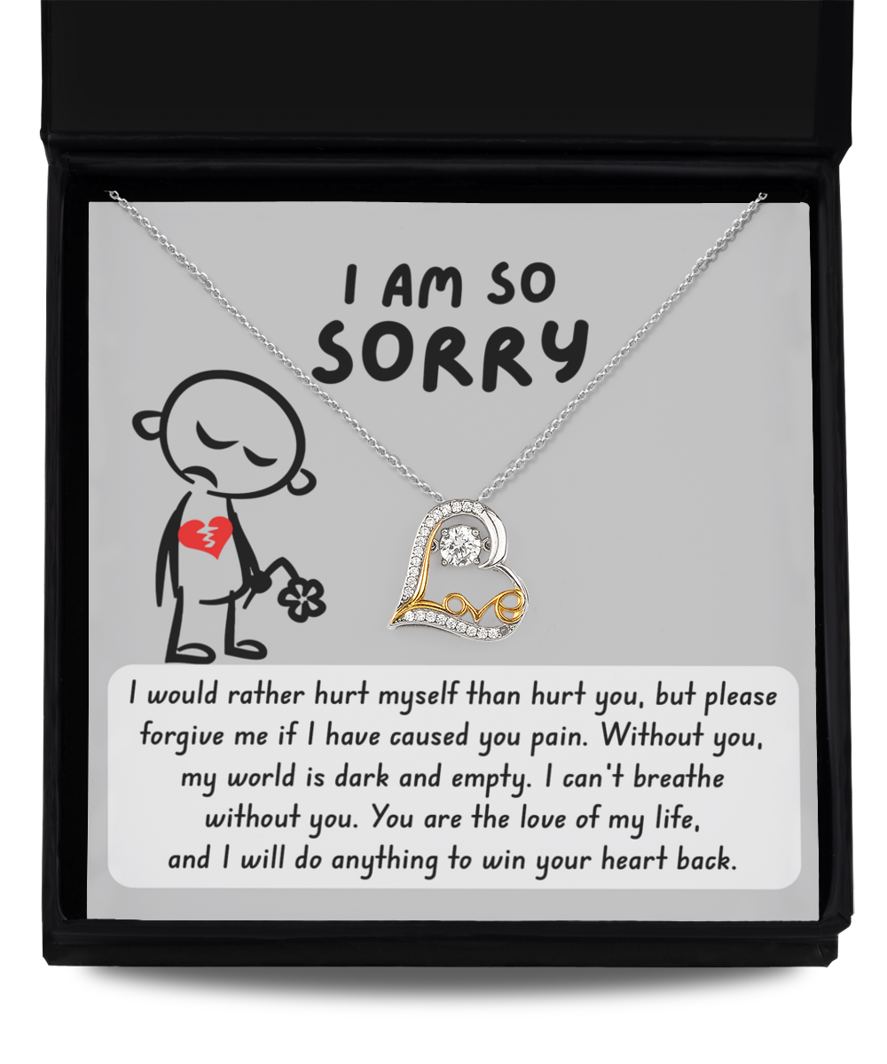 A Sorry-Dark And Empty - Love Dancing Necklace, featuring heart and crystal pendants, is displayed in an open box. The box reads "I AM SO SORRY" with an illustration of a sad figure and a heartfelt apology message below.