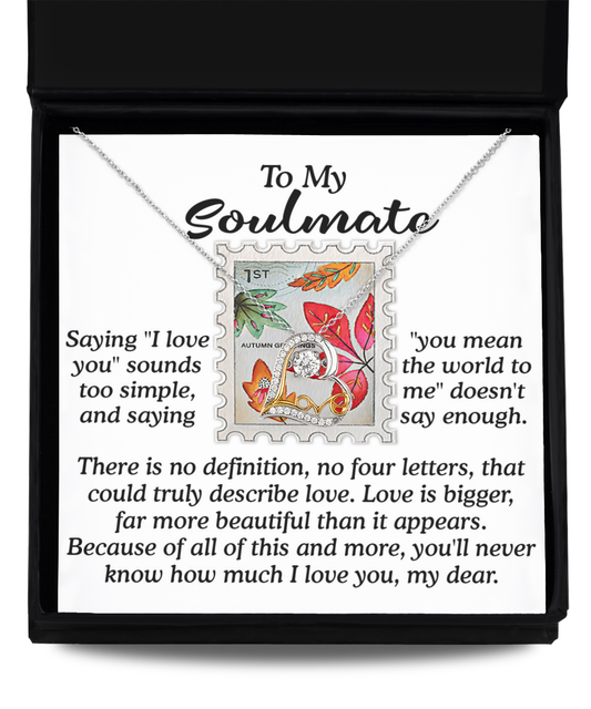 The Soulmate-Far More Beautiful - Love Dancing Necklace is a sterling silver piece featuring a stamp-shaped pendant, elegantly presented in a gift box. It comes with a card that includes a heartfelt message about love, highlighting its profound depth and beauty beyond words.