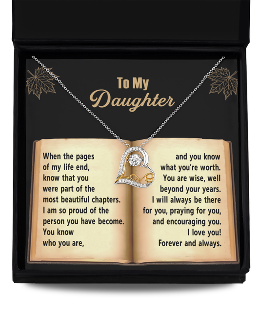 The "Daughter-Beyond Your Years - Love Dancing Necklace," a Sterling Silver piece adorned with a heart pendant featuring a dazzling Cubic Zirconia, rests on an open book inside its box. The book's text conveys a heartfelt message from a parent to their daughter.