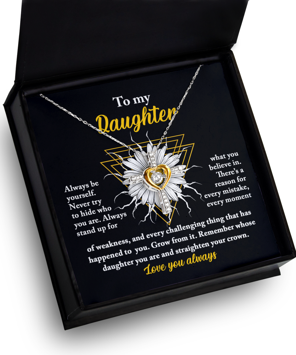 A sterling silver "To Daughter-Be Yourself - Cross Dancing Necklace" with a sunflower pendant in a black gift box. The sunflower has a 14k gold-colored heart in the center. The box displays an inspirational message: "To my daughter: Always be yourself. Never try to hide who you are. Love you always.