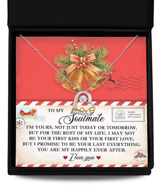 The Soulmate-Happily Ever After - Love Dancing Necklace, crafted from sterling silver, showcases intertwined hearts and is beautifully presented in a black box on a card decorated with bells, pine cones, and a romantic message.