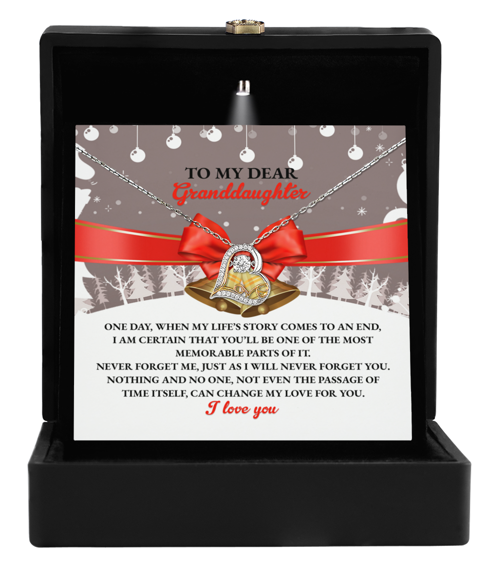 The Granddaughter-Memorable Parts - Love Dancing Necklace is elegantly packaged in a box with a heartfelt message for your granddaughter. This exquisite piece features a heart pendant adorned with a central stone and ribbon design, crafted in 14k gold to add a touch of timeless elegance.