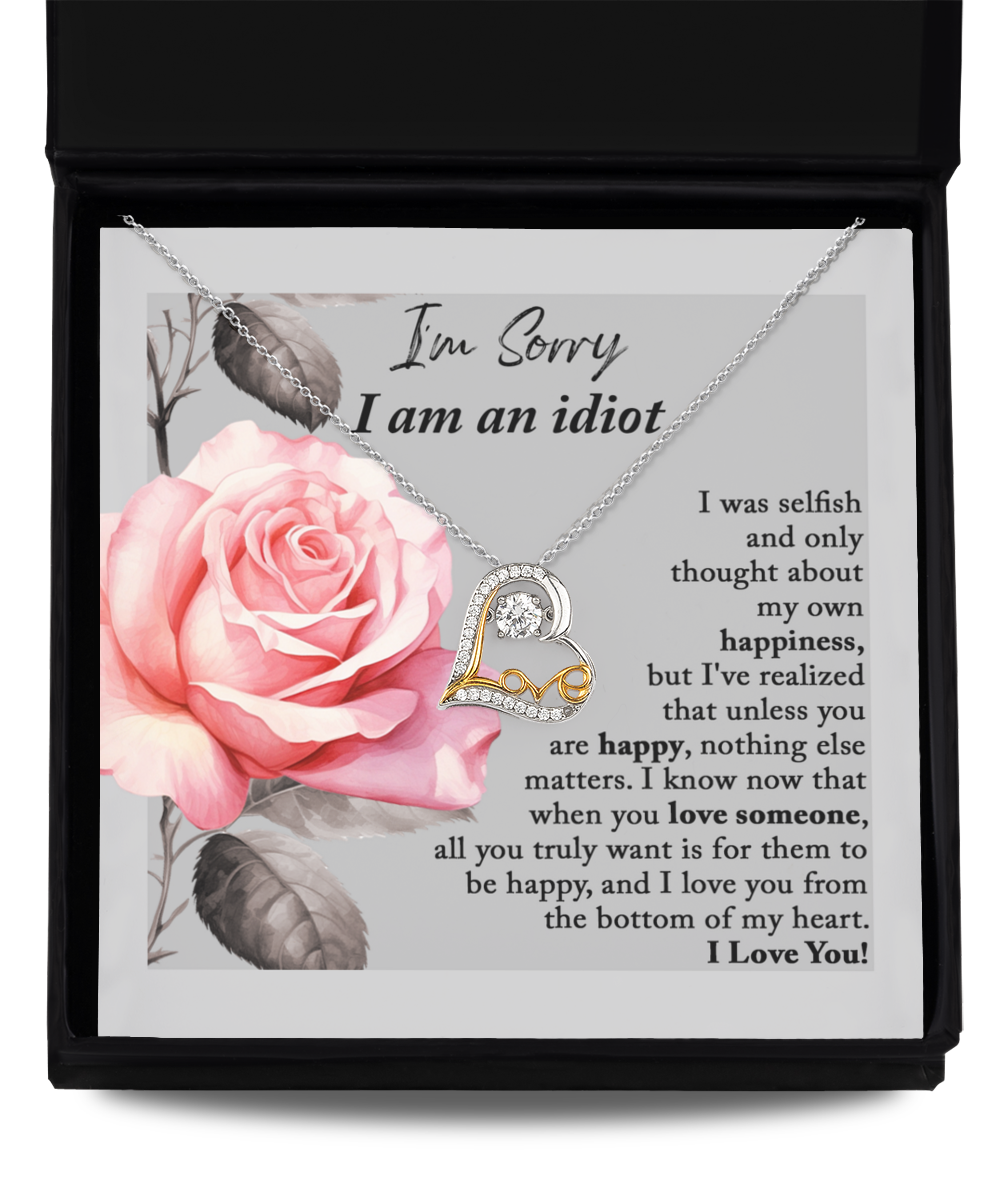 The Sorry-Love Someone - Love Dancing Necklace, crafted in sterling silver with a heart-shaped pendant, is elegantly displayed on a card featuring an image of a pink rose. The heartfelt message accompanying the necklace expresses regret for selfishness and underscores the significance of others' happiness.