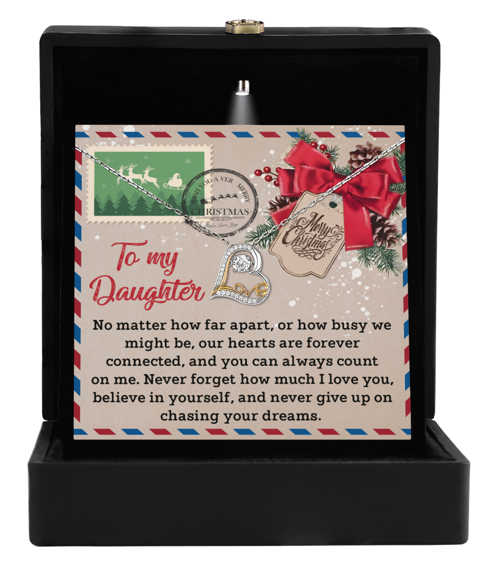 The Daughter-Forever Connected - Love Dancing Necklace showcases a heart pendant crafted in exquisite sterling silver. It is beautifully presented in an elegant box with the heartfelt message: "To my Daughter, our hearts are forever connected. Never forget how much I love you, believe in yourself, and chase your dreams.