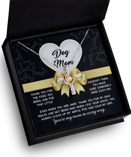 A To Dog Mom, In Every Way - Cross Dancing Necklace with a heart-shaped pendant inscribed with "dog mom" in an open gift box, accompanied by a heartfelt message card and crafted from 14k gold plated metal.