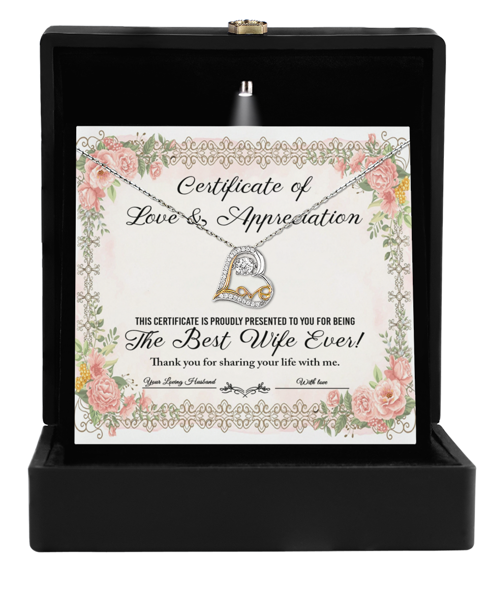 A jewelry box containing the "To Wife-Love & Appreciation - Love Dancing Necklace," crafted in 14k gold with floral designs and accompanied by a certificate titled "The Best Wife Ever," featuring a heart-shaped pendant.