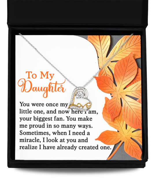 Set against a card adorned with orange leaves, the Daughter-Here I Am - Love Dancing Necklace features a heart-shaped letter "D" crafted in 14k gold. This necklace is accompanied by a heartfelt message from a parent to their daughter, symbolizing eternal love and connection.