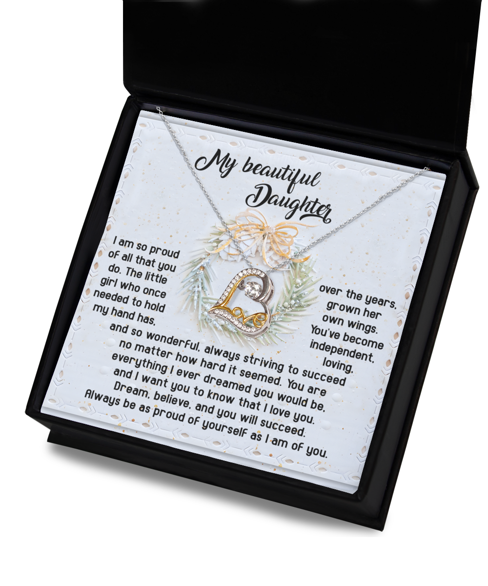 The Daughter-Proud Of Yourself - Love Dancing Necklace, featuring a heart pendant inscribed with "Love," is elegantly presented in an open black box. Made from sterling silver, it includes a message card that begins with "My beautiful Daughter," followed by a heartfelt note.