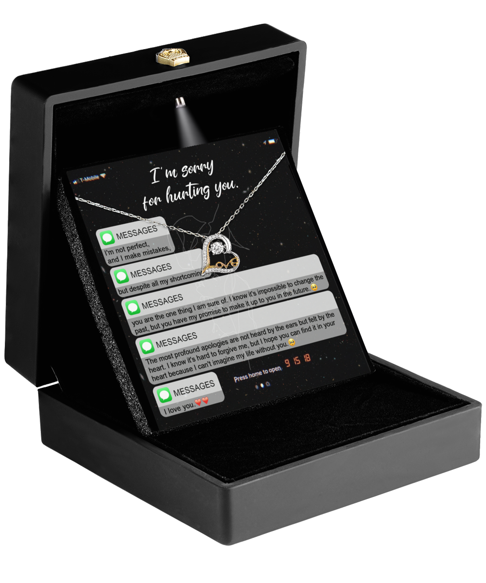 Open black box displaying the Sorry-Life Without You - Love Dancing Necklace, a heart-shaped pendant on a 14k gold chain, with a card above featuring text message conversation.