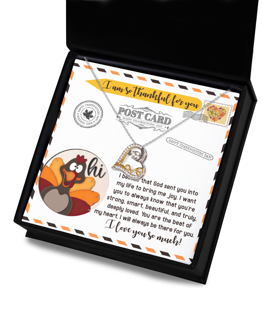 The Thanksgiving-The Beat - Love Dancing Necklace, featuring a beautiful heart pendant, comes elegantly packaged alongside a card. The necklace is crafted in 14k gold and perfectly complements the card's design, which includes a cartoon turkey, Thanksgiving imagery, and a touching message of gratitude. It's the ideal gift for expressing love this holiday season.