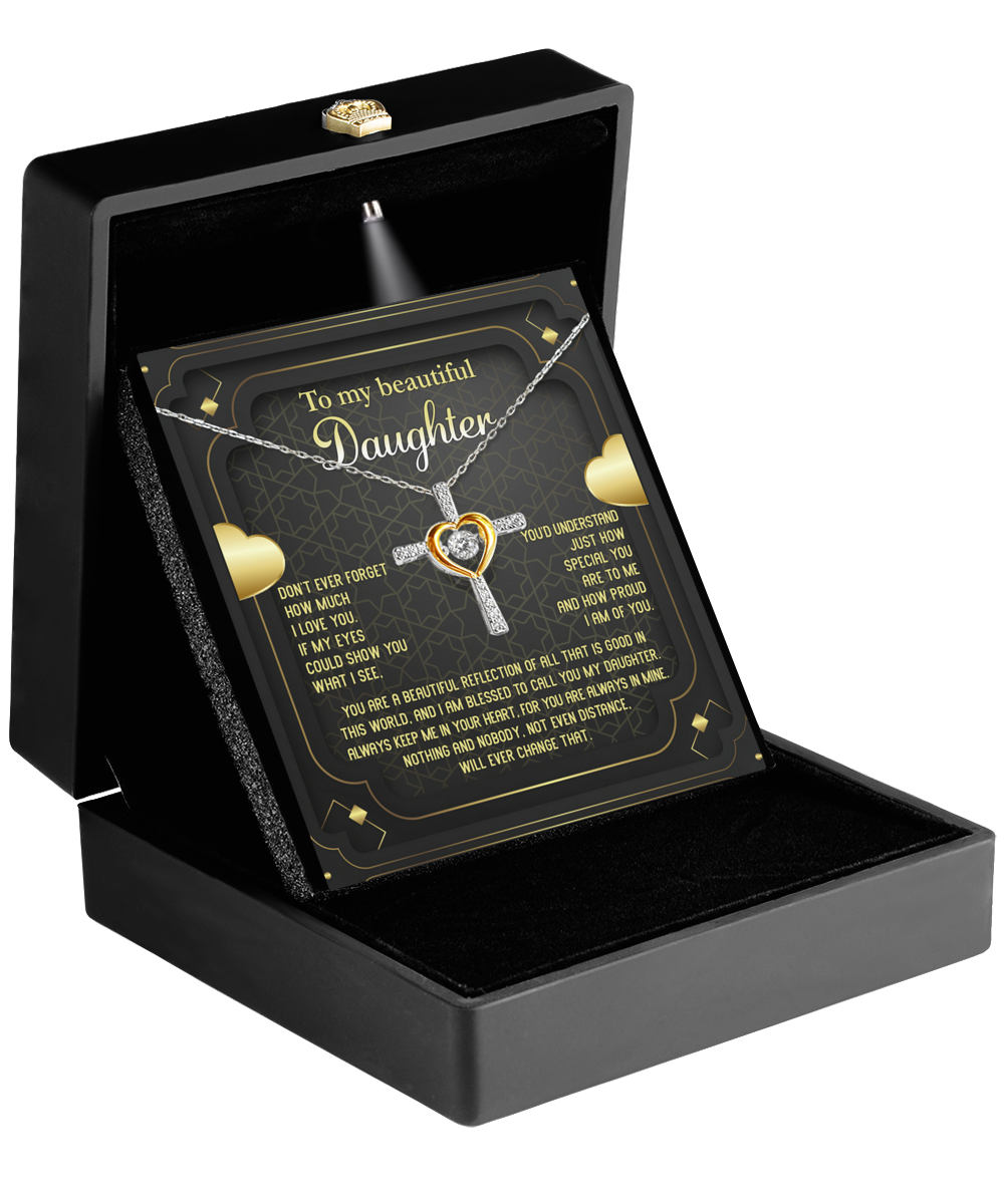 A black jewelry box with the lid open, revealing the "To Daughter-Beautiful Reflection - Cross Dancing Necklace." The interior of the lid has a heartfelt message for a daughter, surrounded by small decorative hearts. The necklace features diamond accents and a 14k gold-tone border.