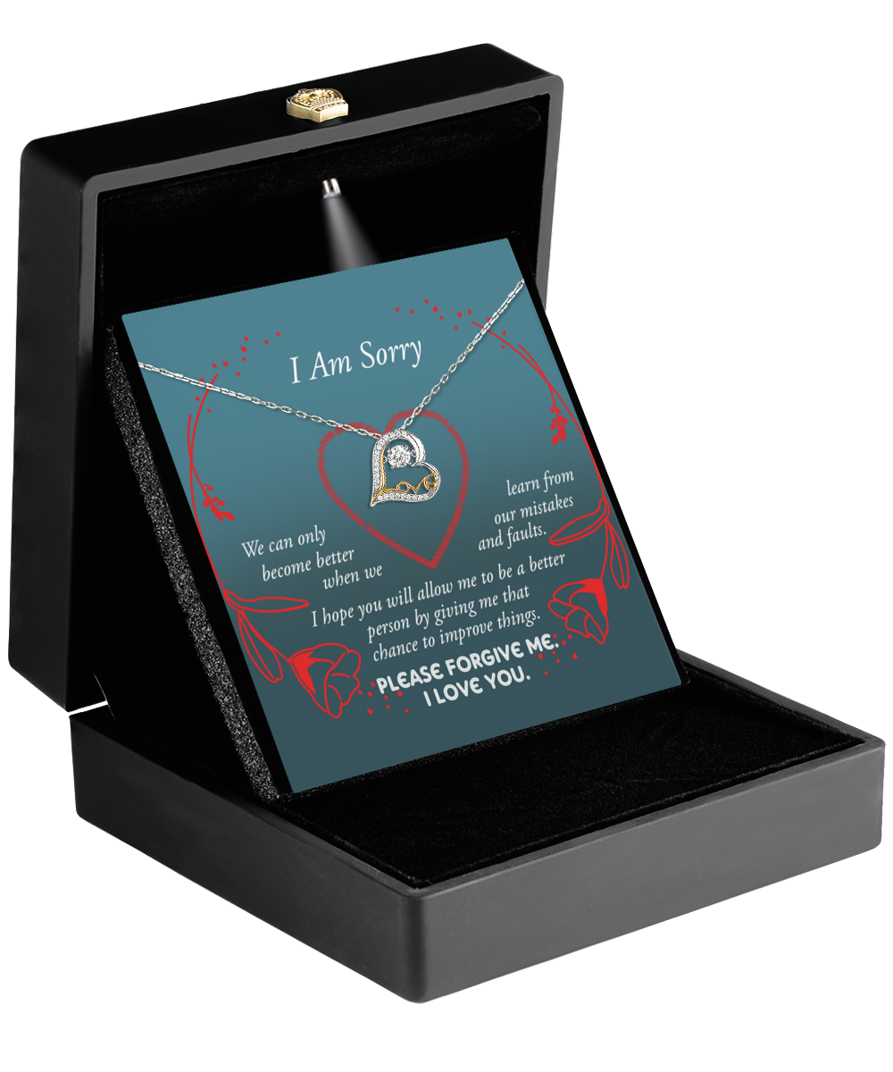 A jewelry box houses the Sorry-Mistakes And Faults - Love Dancing Necklace with a heart pendant, accompanied by a card saying, "I Am Sorry. Please forgive me. I love you.