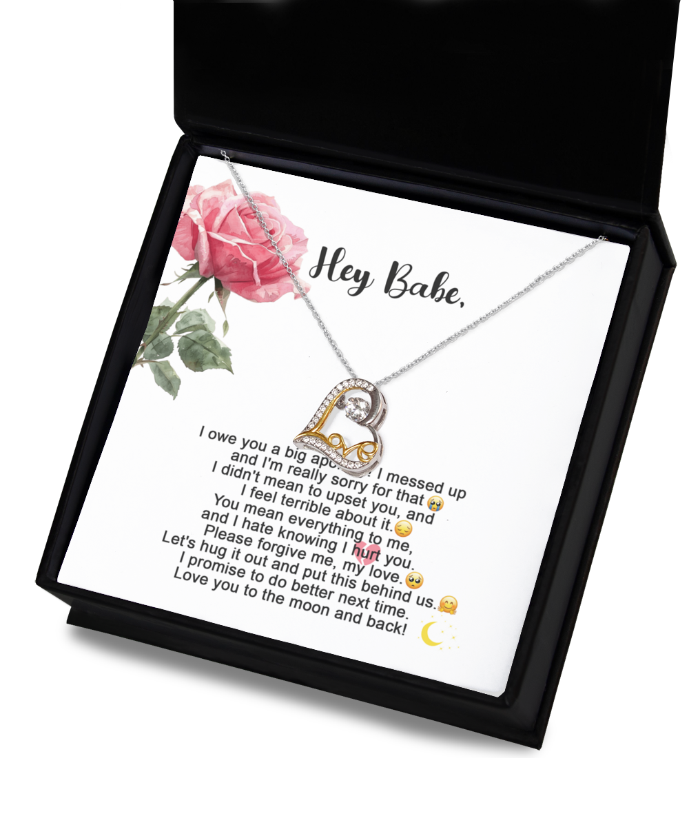 A "Sorry-Hug It Out - Love Dancing Necklace," featuring a heart-shaped pendant on a 14k gold chain, is displayed against a card adorned with an apology message and a pink rose illustration. The message expresses regret, love, and a promise to improve.