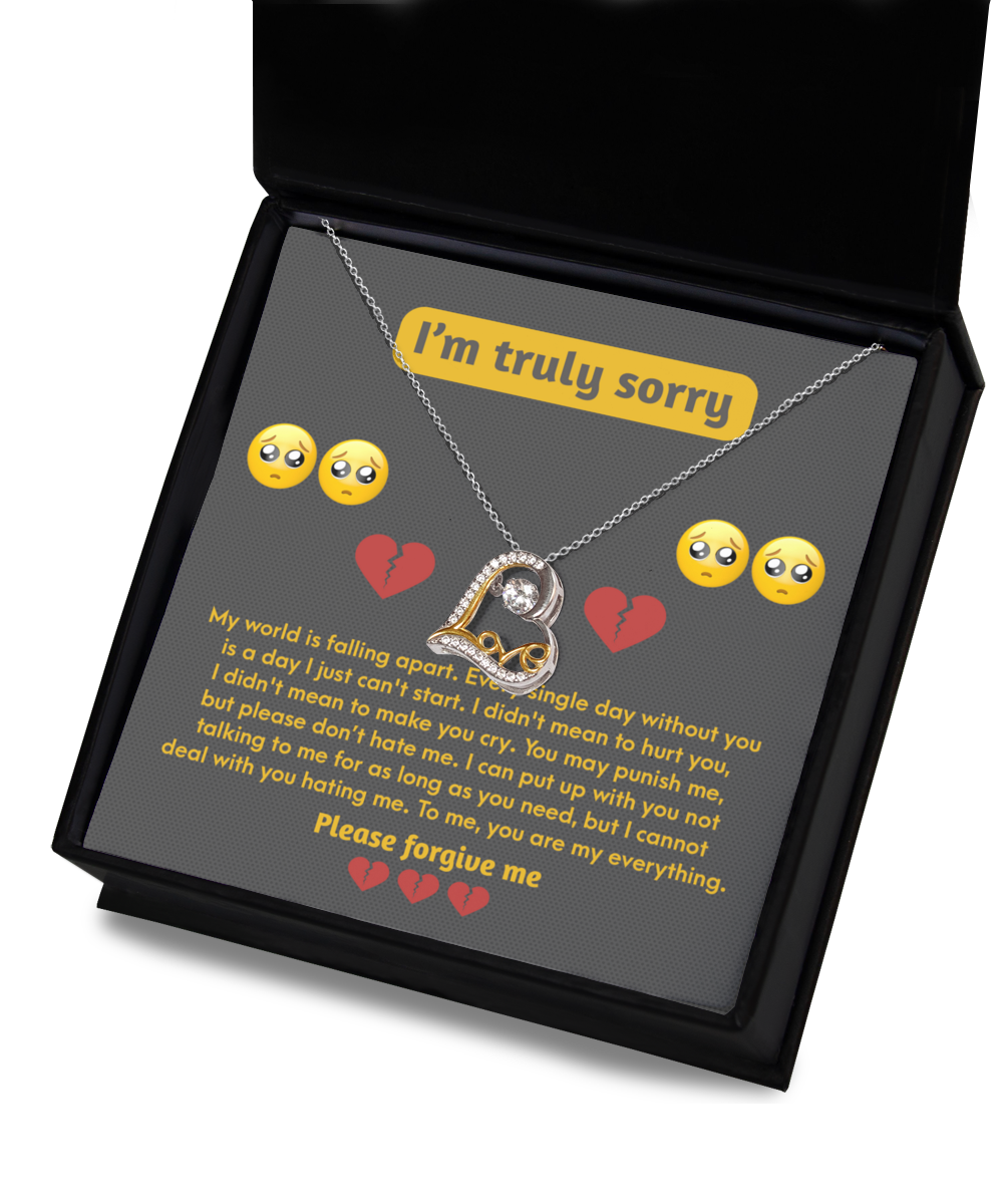 The Sorry-Make You Cry - Love Dancing Necklace, a sterling silver heart necklace presented in a sleek black box, comes with a heartfelt apology note displayed inside the lid and adorned with crying emoji and heart illustrations.