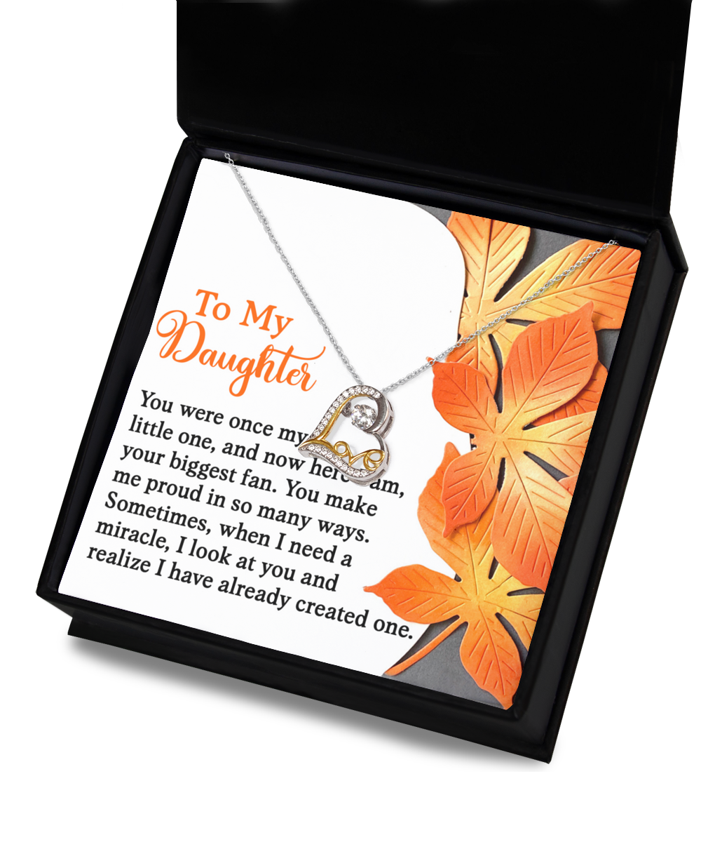 A Daughter-Here I Am - Love Dancing Necklace crafted from sterling silver rests in a jewelry box. The lid features an orange and white card reading "To My Daughter," adorned with decorative leaves.