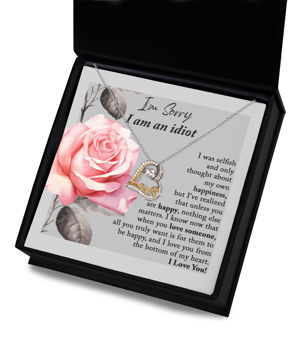 The Sorry-Love Someone - Love Dancing Necklace, crafted in sterling silver with a heart-shaped pendant, is elegantly displayed on a card featuring an image of a pink rose. The heartfelt message accompanying the necklace expresses regret for selfishness and underscores the significance of others' happiness.