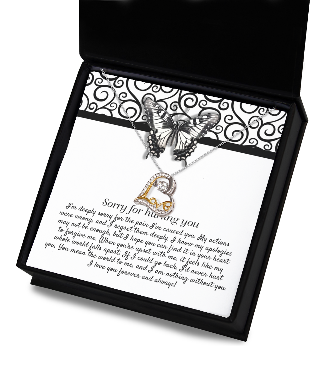 The Sorry-Nothing Without You - Love Dancing Necklace is a .925 sterling silver piece featuring a pendant of interlocking hearts. It is beautifully displayed on a card adorned with an apology message and a butterfly graphic, all elegantly packaged in a black box. The text on the card conveys regret and love.