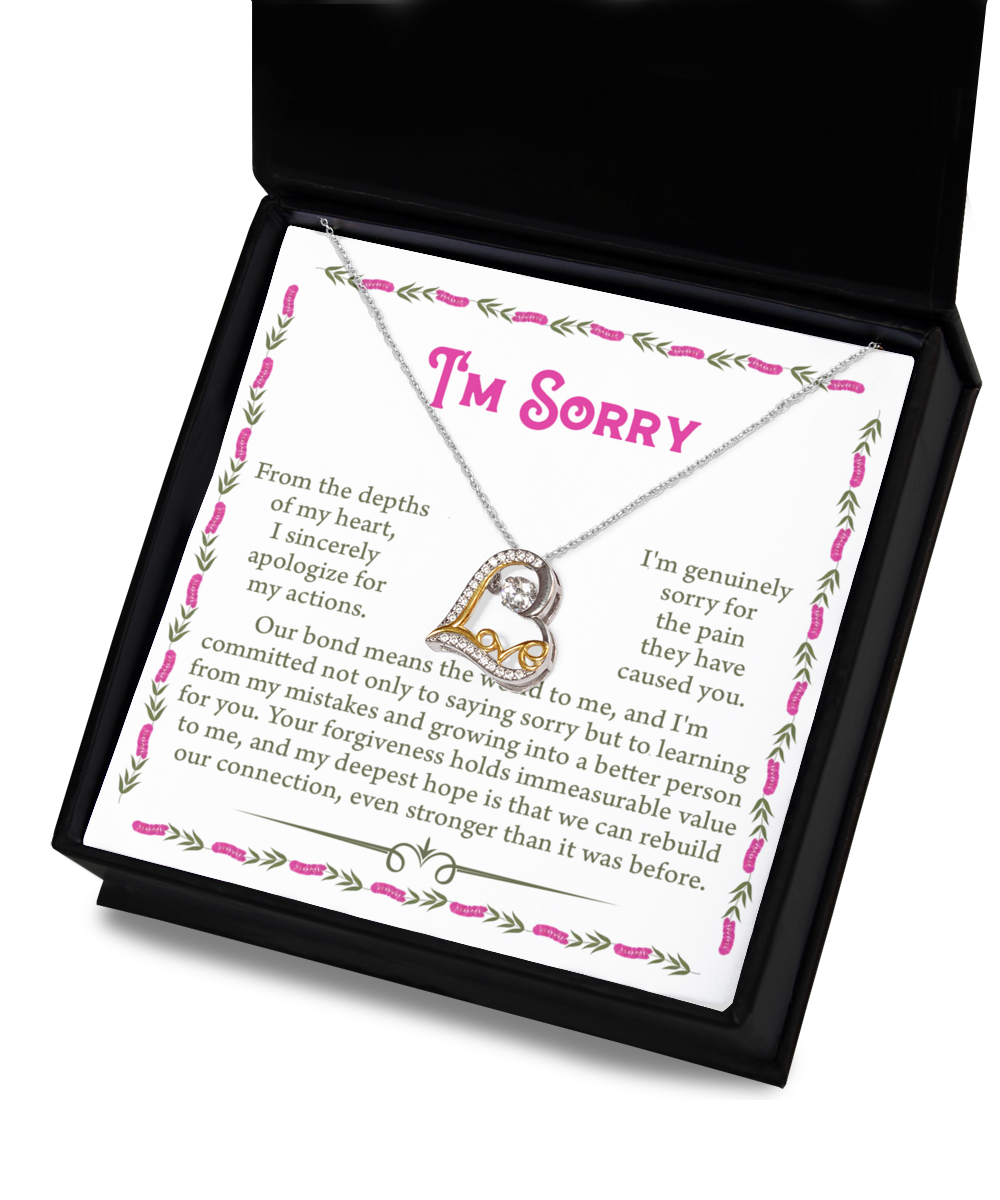 A 14k gold plated necklace with a pendant inside a box. The box includes a card with an apology message and the words "I'm Sorry" at the top. This is the "Sorry-A Better Person - Love Dancing Necklace".