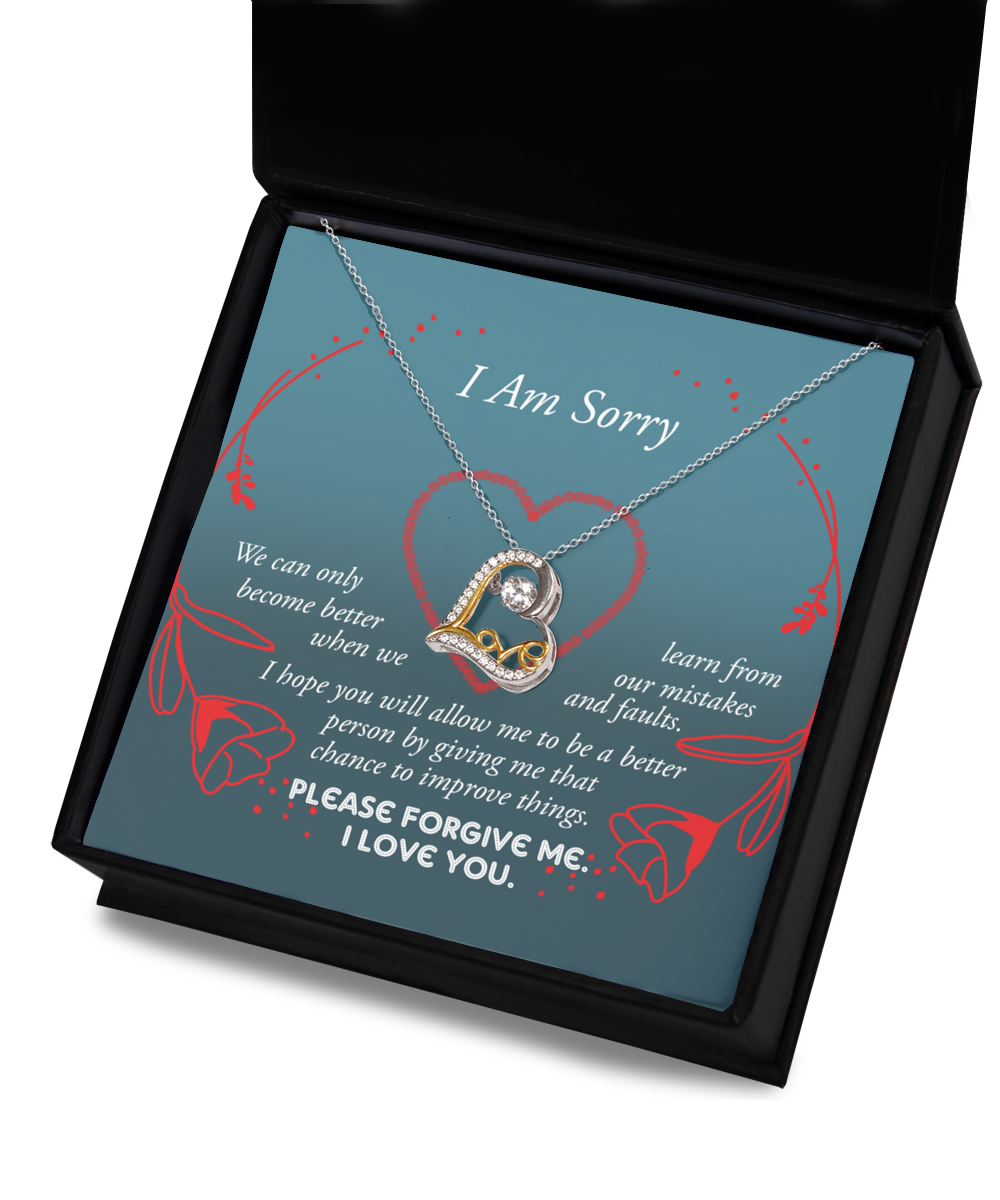 The "Sorry-Mistakes And Faults - Love Dancing Necklace" features an intertwined heart pendant, expertly crafted in .925 Sterling Silver. It is presented on a card reading "I Am Sorry," which includes a heartfelt apology message emphasizing growth and the pursuit of forgiveness, adorned with elegant red rose graphics.