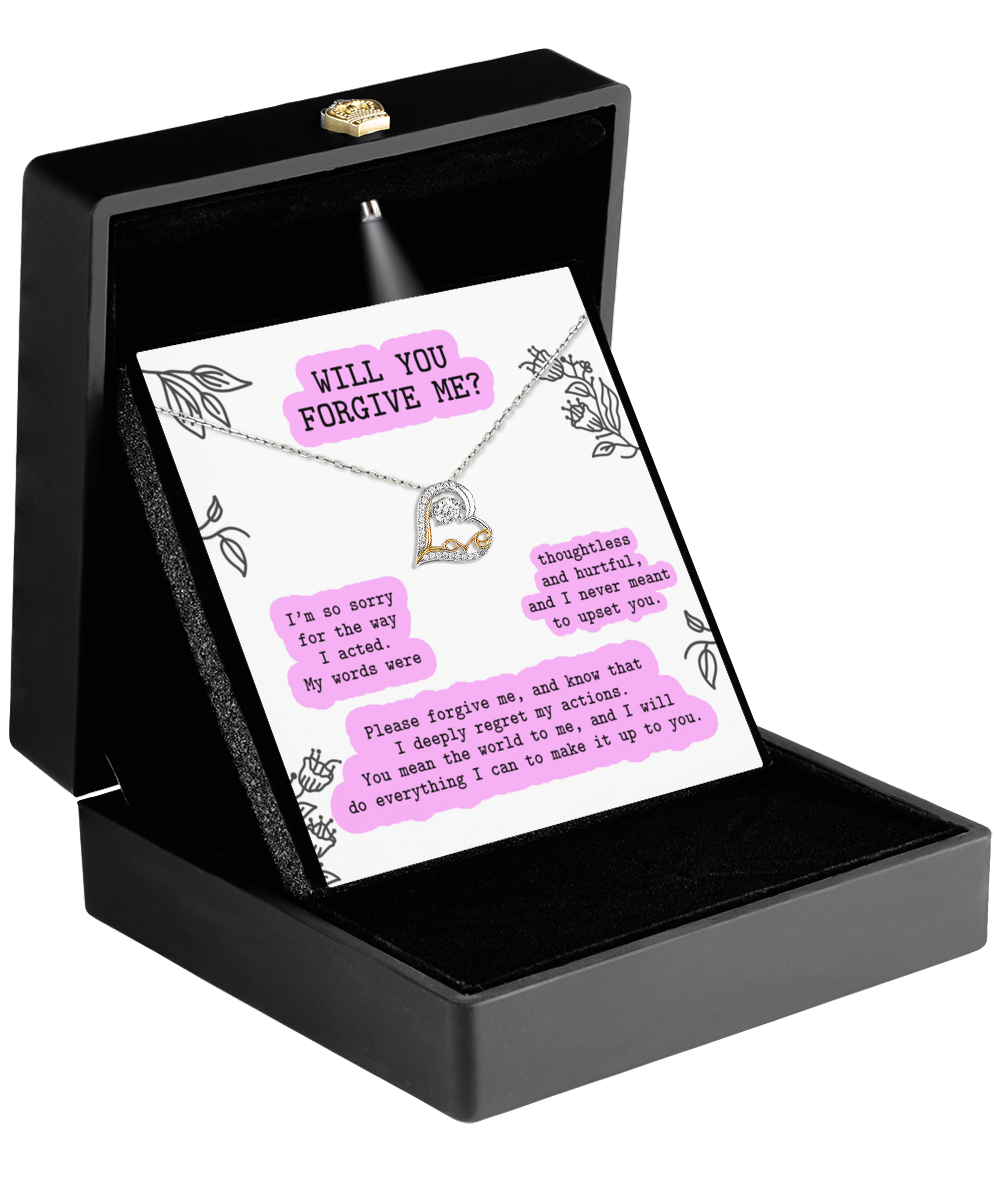 A black jewelry box showcases the Sorry-Never Meant To - Love Dancing Necklace, crafted from hypoallergenic sterling silver and featuring a heart pendant. Behind the necklace is a card with apologetic messages on a light background, asking for forgiveness.