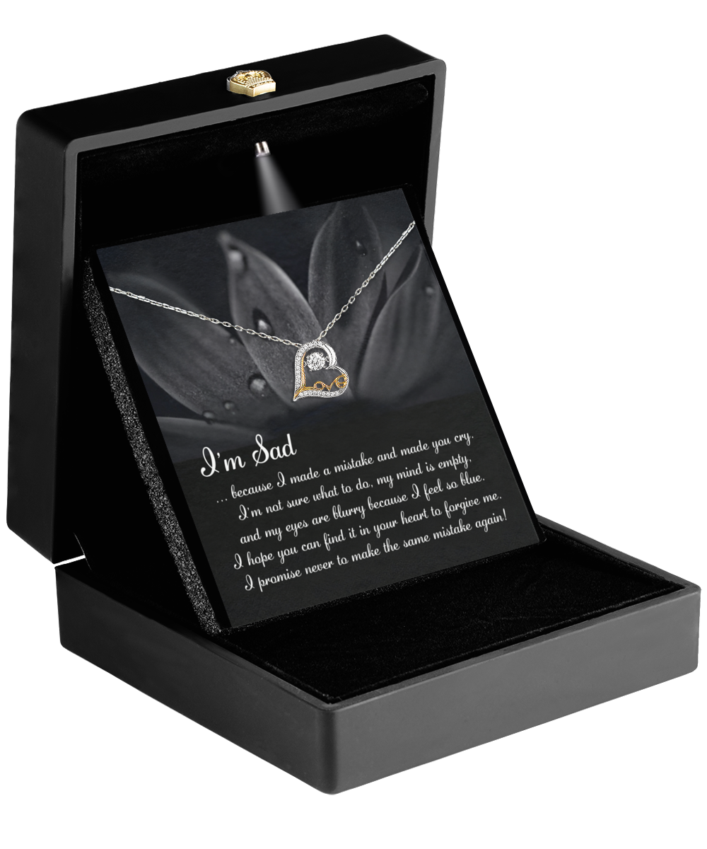 The Sorry-Feel So Blue - Love Dancing Necklace features a heart-shaped pendant in an open black jewelry box. The included card reads "I'm Sad," expressing regret and a promise to never repeat the mistake, making it a thoughtful gift for your wife.