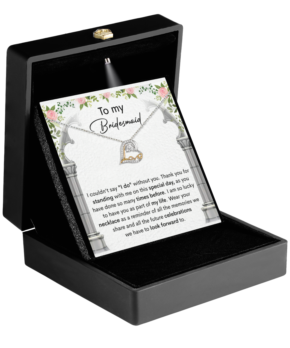 A jewelry box featuring the Bridesmaid-Standing With Me - Love Dancing Necklace, showcasing a heart pendant. Accompanying it is a floral card titled "To my Bridesmaid" with a heartfelt message, making it the perfect elegant gift for your cherished bridesmaid.