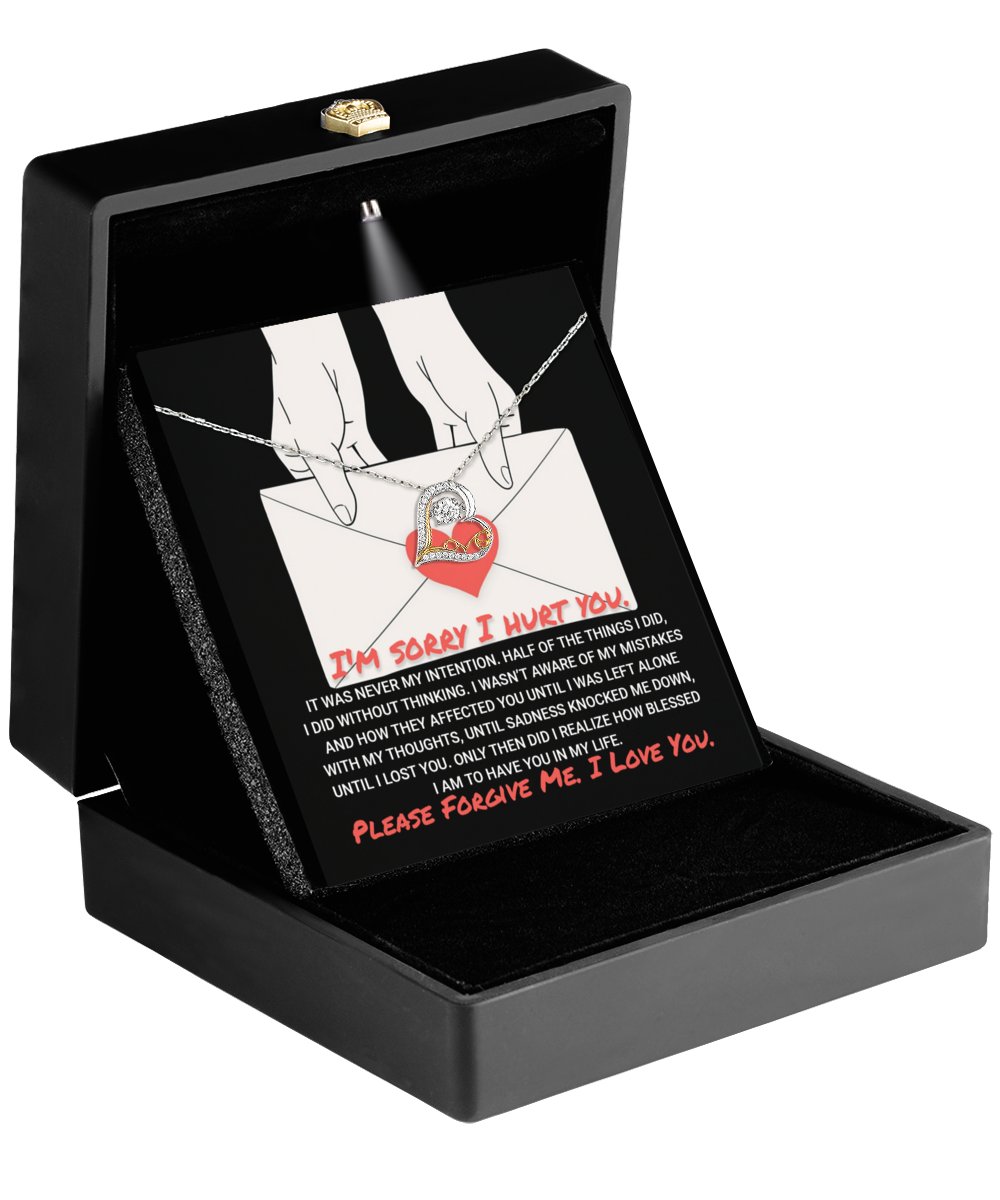 The black jewelry box opens to reveal a Sorry-Without Thinking - Love Dancing Necklace, elegantly designed with a heart-shaped pendant. Inside the lid, a heartfelt apology note is displayed in striking red text: "I'm sorry I hurt you. Please forgive me. I love you.