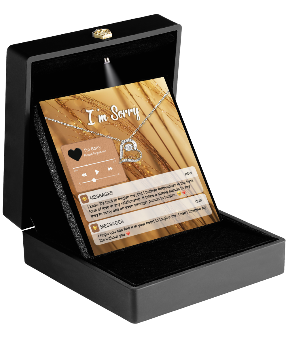 The Sorry-Person To Forgive - Love Dancing Necklace, featuring a heart-shaped pendant, is presented in a jewelry box with an "I'm Sorry" message card.