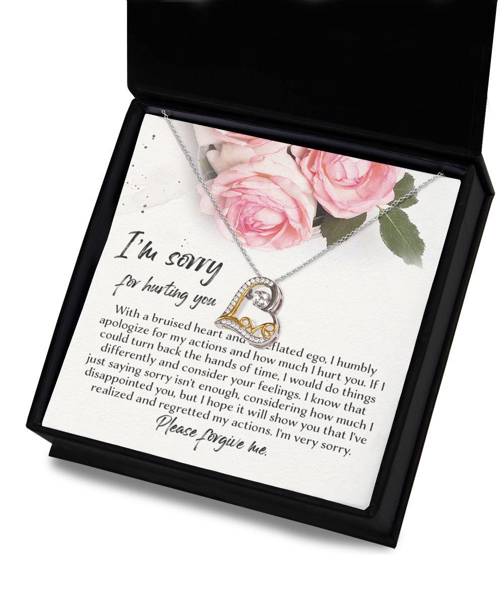 A jewelry box is open, revealing a letter and a "Sorry-Regretted My Actions - Love Dancing Necklace," crafted from .925 Sterling Silver with a heart-shaped pendant. The letter contains a heartfelt apology, expressing regret and pleading for forgiveness. The box's interior lid showcases an image of pink roses.