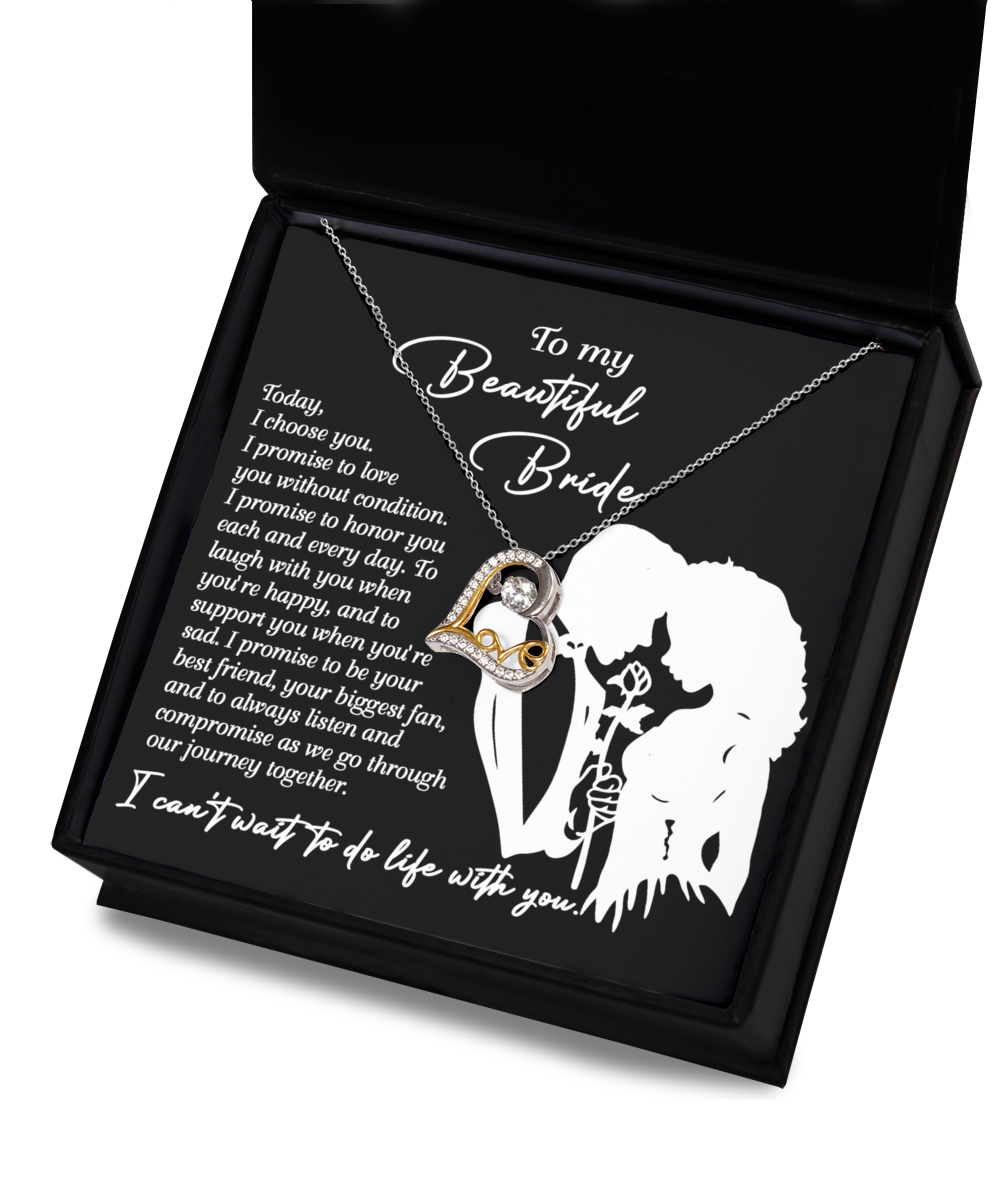 A Bride-I Choose You - Love Dancing Necklace featuring a heart and crystal pendant is displayed in a box. The lid showcases a silhouette of a couple, with text beginning "To my Beautiful Bride" followed by a romantic message. The pendant is available in Sterling Silver or 14k gold for an elegant touch.