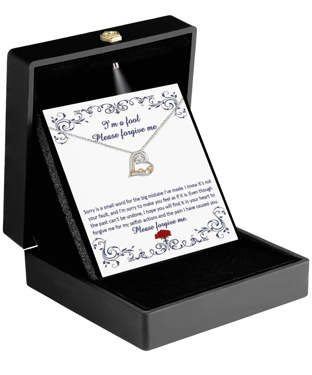 The Sorry-I'm A Fool - Love Dancing Necklace, featuring a heart pendant in 14k gold, is presented in an open black box with a card stating, "I'm a fool, please forgive me," reflecting deep remorse and the nurturing essence of maternal love.