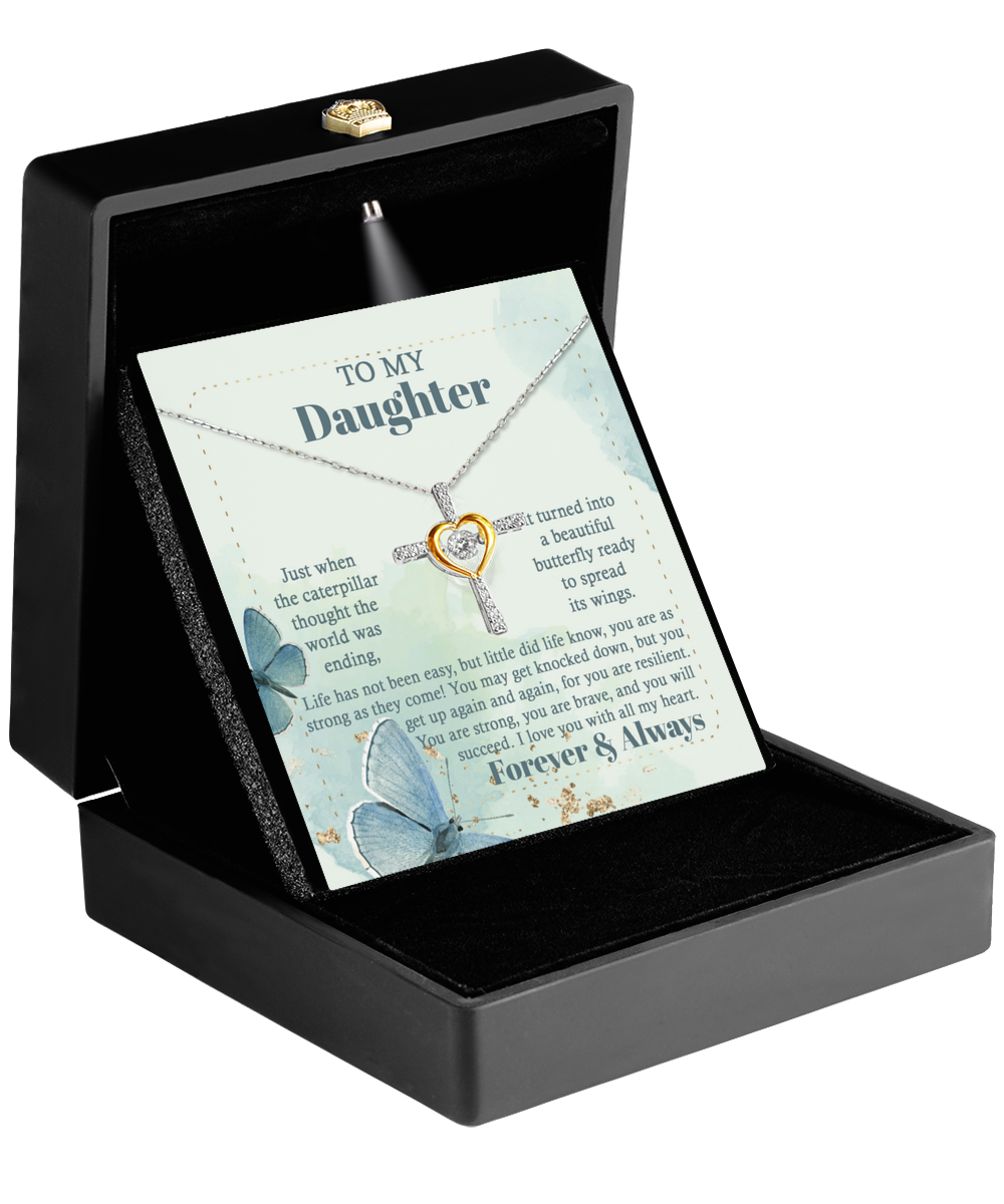 A jewelry box displays the "To Daughter-Beautiful Butterfly - Cross Dancing Necklace" in sterling silver. Behind the necklace is a message that reads, “To my daughter. Just when the caterpillar thought the world was over, it became a butterfly.” Blue butterflies and sentimental text decorate the background.