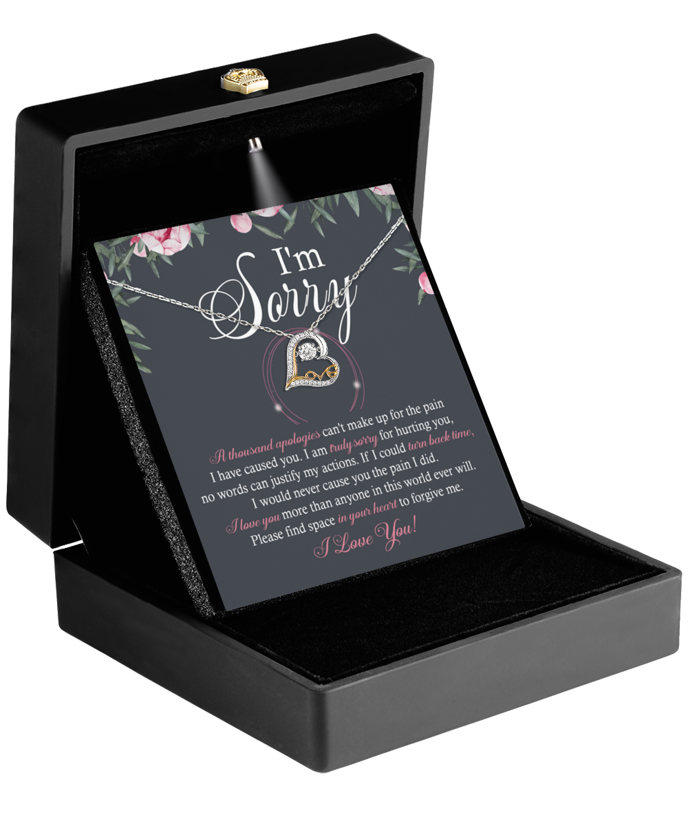 The Sorry-World Ever Will - Love Dancing Necklace features a stunning heart-shaped pendant adorned with a diamond, elegantly presented in a black box. It is accompanied by a card inscribed with "I'm Sorry" and an earnest message about love and forgiveness, all expertly crafted in 14k gold.