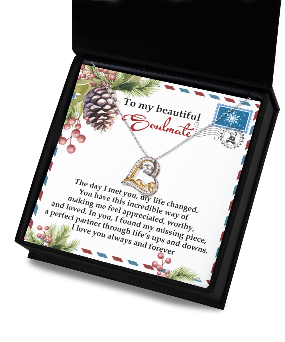 The Soulmate-Perfect Partner - Love Dancing Necklace, showcasing a heart-shaped pendant crafted from sterling silver, is elegantly presented in a charming box. It comes with a card featuring a romantic message beautifully decorated with pine cones and foliage.