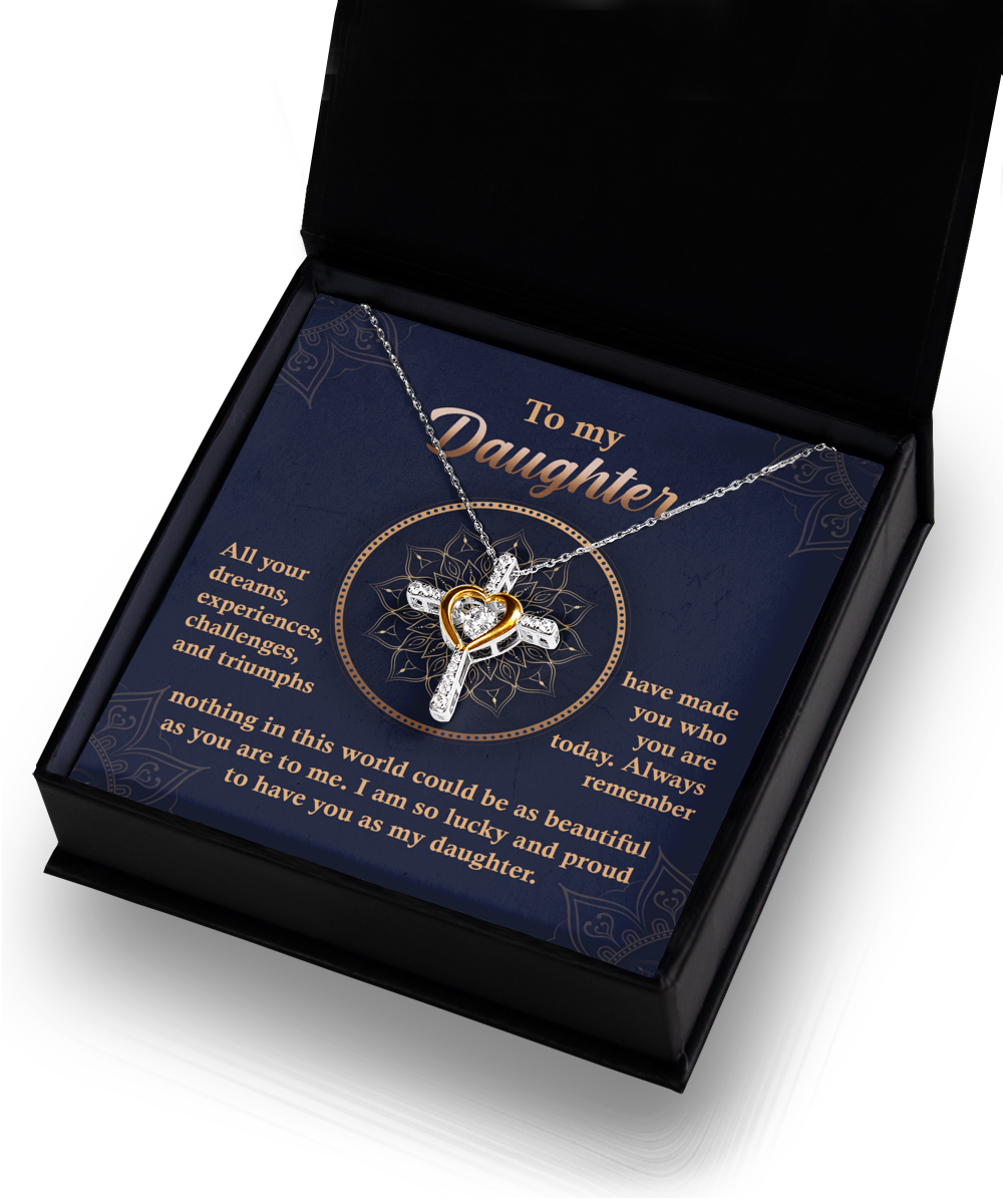 A Daughter-All Your Dreams - Cross Dancing Necklace with a heart-shaped centerpiece is displayed in an open box. The message on the box is addressed to a daughter, expressing pride and love.