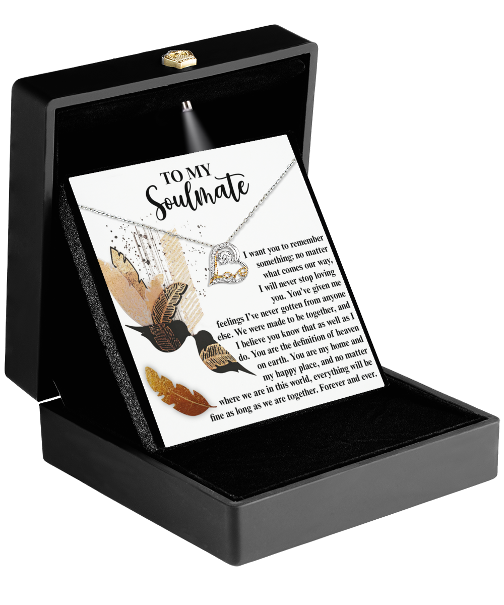 Inside a black jewelry box, the Soulmate-Given Me Feelings - Love Dancing Necklace, featuring a sterling silver heart-shaped pendant, is accompanied by an inscribed card adorned with feather designs and the message "To My Soulmate.