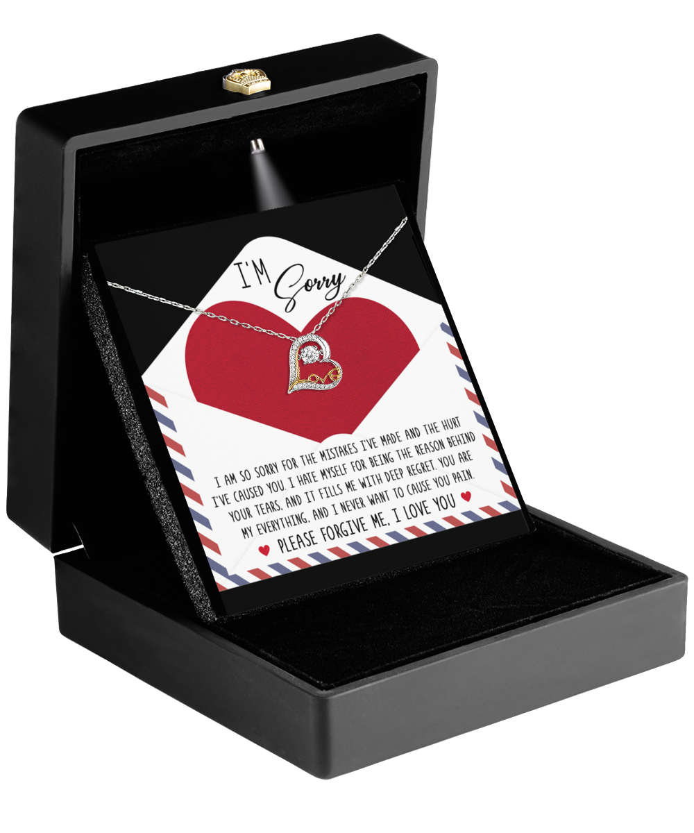 A black jewelry box is open, revealing the Sorry-Behind Your Tears - Love Dancing Necklace with a heart-shaped pendant and a card with an apology message, featuring the words "I'm Sorry" at the top. The stunning 14k gold pendant captures the essence of true regret and heartfelt emotion.