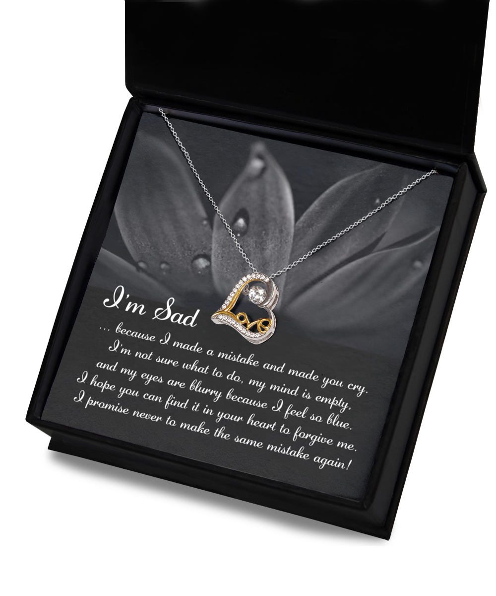 The "Sorry-Feel So Blue - Love Dancing Necklace," a heart-shaped pendant crafted with genuine .925 Sterling Silver and AAAA Cubic Zirconia, is displayed in an open box with a message that reads: "I'm Sad...because I made a mistake and made you cry... I promise never to make the same mistake again.