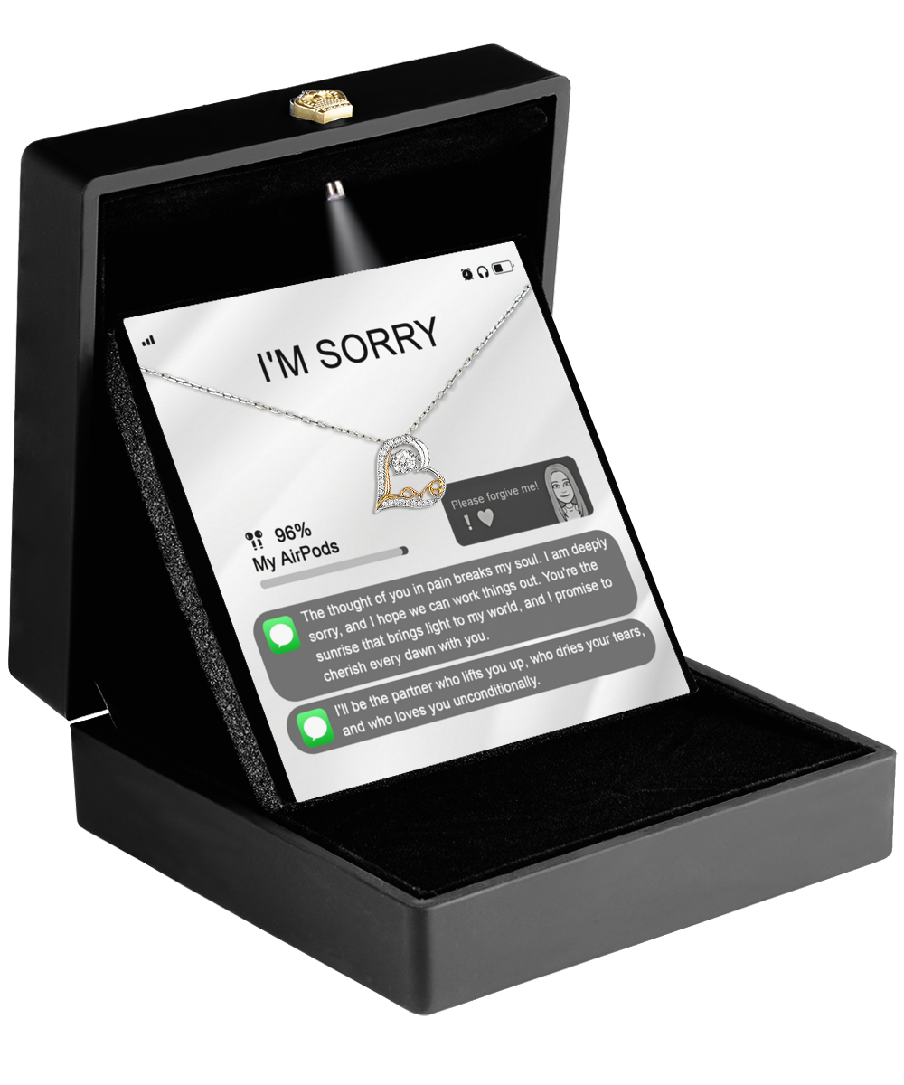 A black jewelry box is opened to reveal the Sorry-Breaks My Soul - Love Dancing Necklace, crafted from 14k gold and featuring a heart-shaped pendant. Inside the lid, there's a heartfelt apology along with a visible text exchange.