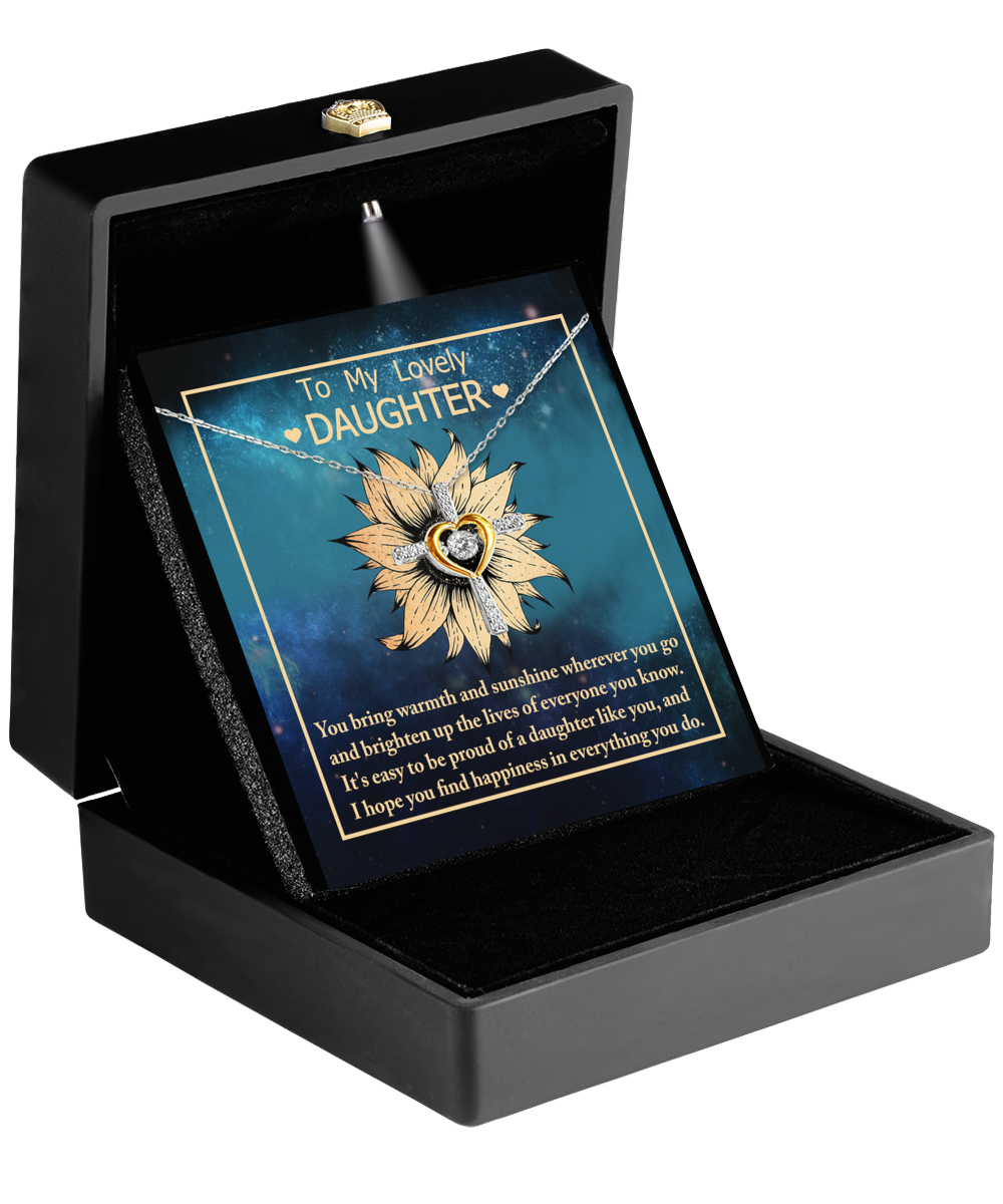 An open black jewelry box displays the "To Daughter - Be Proud Of" cross dancing necklace. The box lid holds a message card that reads, "To My Lovely Daughter," followed by a heartfelt note expressing love and good wishes. For added elegance, this necklace design is also available in Rhodium-Plated Sterling Silver.