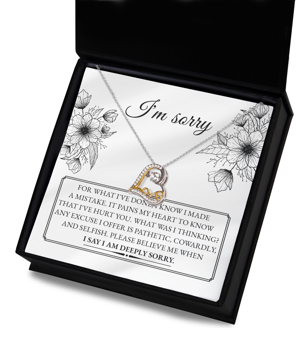 A 14k gold necklace with an intertwined heart design from the "Sorry-Made A Mistake - Love Dancing Necklace" collection is presented in a box. The text inside conveys an apology for causing pain, expressed with deep regret and a heartfelt plea to believe in the sincerity of the apology.