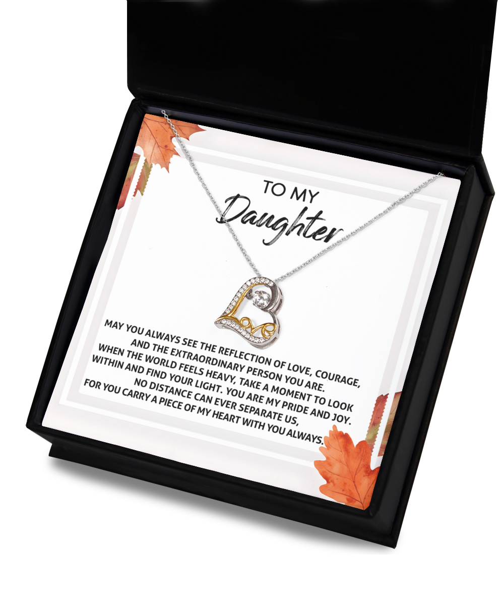 The Daughter-Find Your Light - Love Dancing Necklace features a crescent and heart pendant, beautifully crafted in 14k gold and elegantly presented in a gift box. Accompanying the necklace is a card with the message "To my Daughter," surrounded by autumn leaves, conveying a heartfelt sentiment.