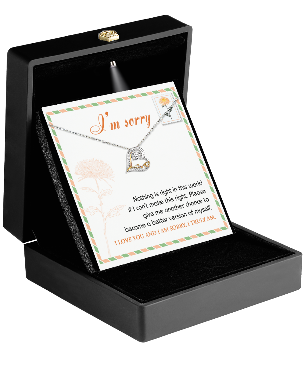 The Sorry-Another Chance - Love Dancing Necklace, crafted in 14k gold and featuring a heart-shaped pendant, is elegantly presented in a black box with an "I'm sorry" message card on top.