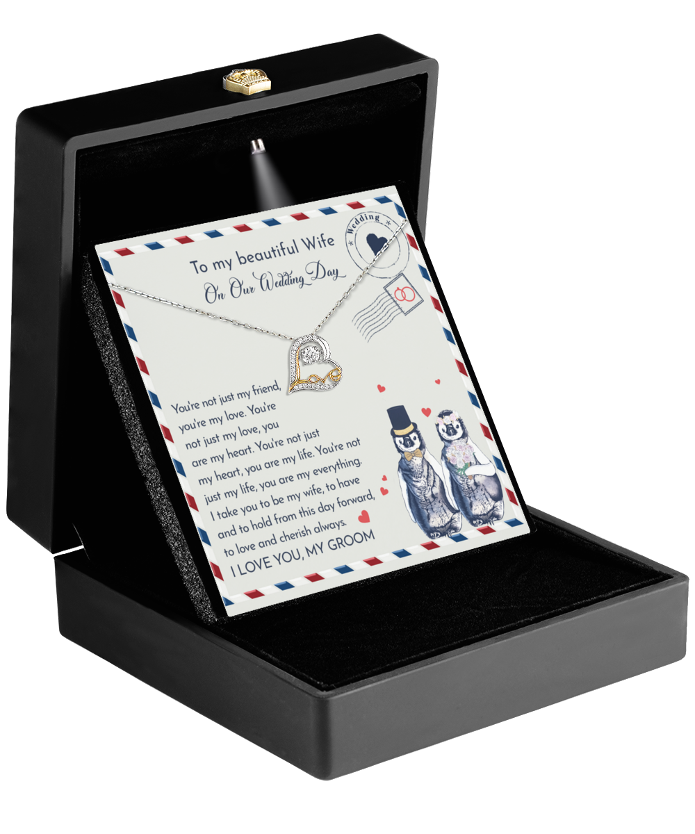 The "To Wife Wedding, Love And Cherish - Love Dancing Necklace," featuring a 14k gold heart pendant, rests in an open black box and is paired with a card containing a sentimental message—the perfect gift for your wife on your wedding day.