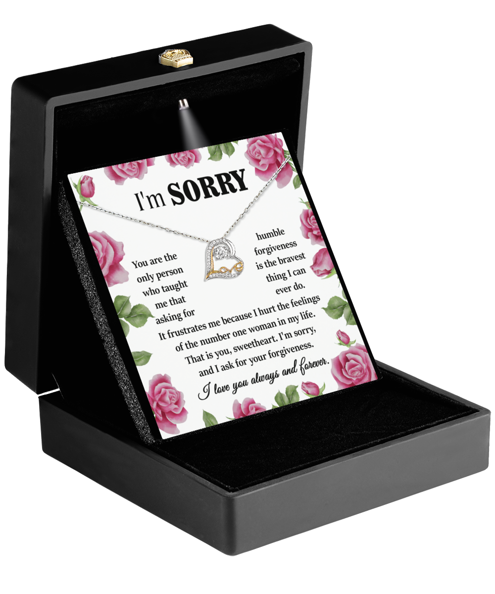 A "Sorry-Your Forgiveness" black jewelry box with a heartfelt apology message inside, accompanied by a .925 Sterling Silver Love Dancing Necklace. The card features decorative pink roses and an earnest apology note.