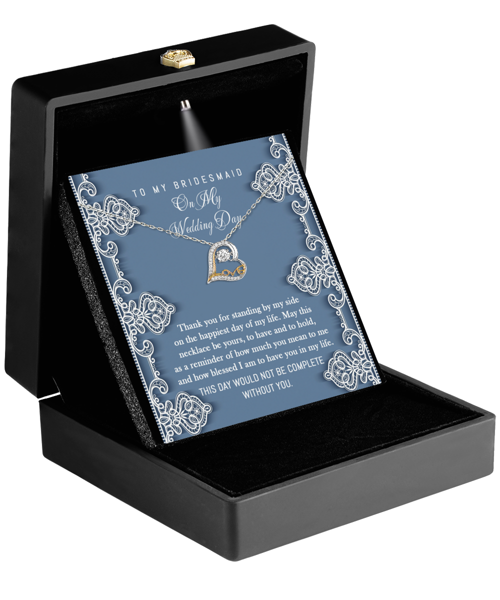 The elegant Bridesmaid-By My Side - Love Dancing Necklace, adorned with a heart-shaped pendant, is beautifully presented in an open black box with a card that reads "To My Bridesmaid" on a decorative background.