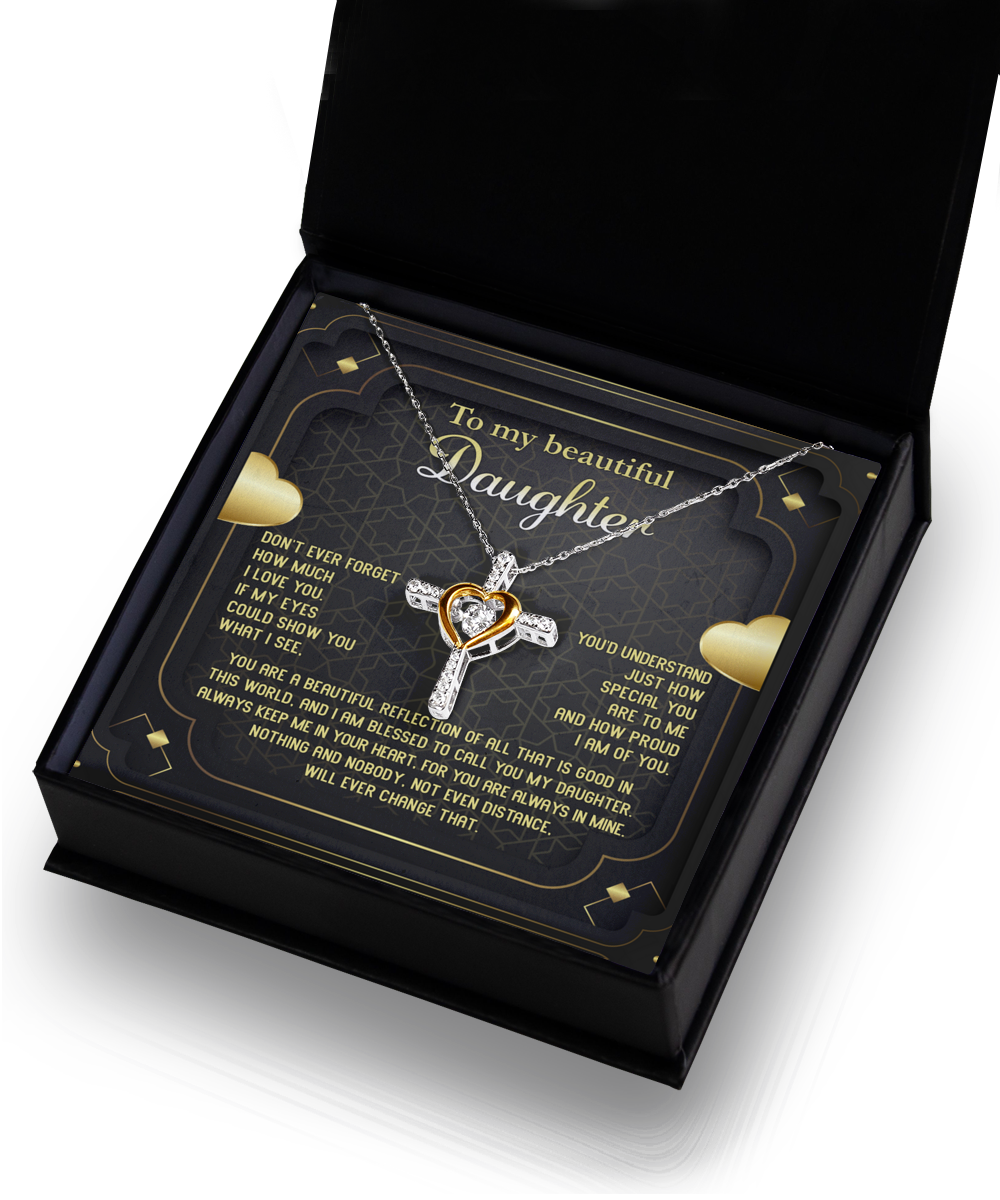 The "To Daughter-Beautiful Reflection - Cross Dancing Necklace" with an intertwined heart and cross pendant is elegantly displayed in an open black box. Crafted from .925 Sterling Silver, the box lid features a heartfelt message to a daughter, surrounded by gold hearts, and adorned with decorative, ornate elements in the background.